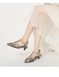 Close-up of elegant woven kitten heel sandals with a snakeskin print and pointed toe.