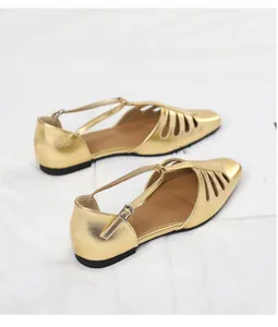 Close-up detail of gold vintage square toe hollow-out flat sandals with T-strap and buckle