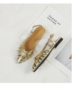 Close-up of gold woven hollow sandals with bow detail and slingback strap