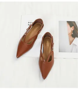 Draufsicht auf braune spitze Ballerinas mit eleganten Kreuzriemen und Schnallen