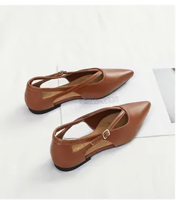 Detailansicht brauner spitzer Ballerinas mit Kreuzriemen und Metallschnallen