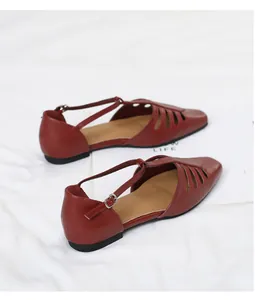 Close-up of burgundy vintage square-toe cutout flat sandals with elegant T-strap