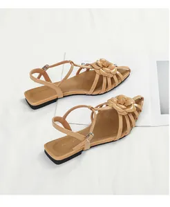 Detailed top view of beige camellia flat sandals with strap design on minimalist background