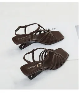 Top-down view of brown strappy sandals with square toes and sculptural mid-heels