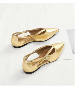 Detailansicht goldener spitzer Ballerinas mit elegantem Kreuzriemen- und Schnallen-Design