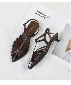 Detail shot of brown pointed toe kitten heel sandals with woven hollow-out design.