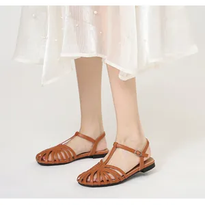 Model wearing vintage brown hollow-out closed-toe sandals with T-strap and pearly skirt