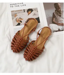 Close-up detail of brown hand-woven closed-toe Roman sandals with ankle strap