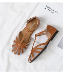 Dettaglio di ballerine vintage in mesh marrone con cinturino a T intrecciato