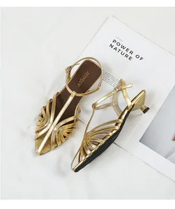 Detail view of stylish golden strappy kitten heel sandals with elegant pointed toe