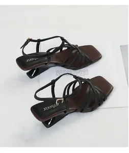 Detailed view of vintage square toe sandals with black crisscross straps and unique heel
