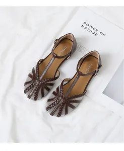 Dettaglio di scarpe basse con cinturino a T in mesh vintage con design intrecciato e fibbia