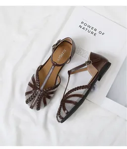 Vista dettagliata di scarpe basse in rete vintage con cinturino a T intrecciato e fibbia