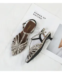 Macro detail view of woven snakeskin kitten heel sandals with elegant pointed toe.