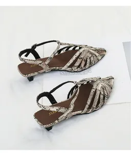 Detail view of stylish faux snakeskin kitten heel sandals with braided multi-strap design