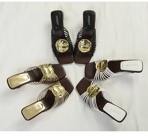 Detail of French style mules with gold metal disk and radiant straps in three colors