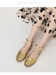 Close-up of golden handmade woven caged flat sandals worn by model in floral dress