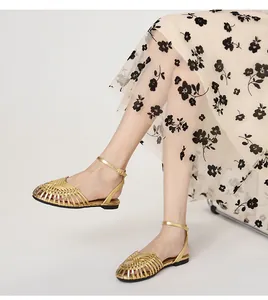 Detailed view of women's vintage golden hand-woven closed-toe sandals with ankle strap