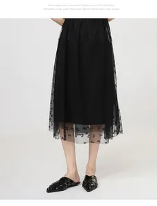 Elegant black woven pointed-toe mule slippers paired with a stylish tulle skirt.
