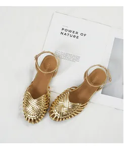 Detailed top view of gold hand-woven retro Roman style flat sandals with ankle straps.
