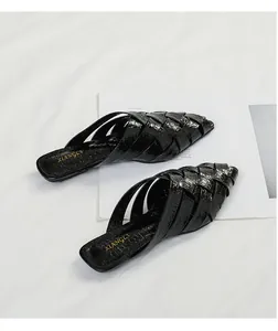Elegant black woven pointed-toe mules displayed on a minimalist white background