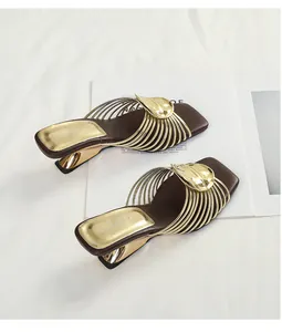 Top view of gold metallic sandals with radiating straps and irregular geometric heels.