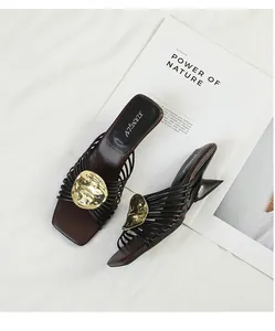 Detailed view of French style sandals with metallic radiating straps and irregular heels