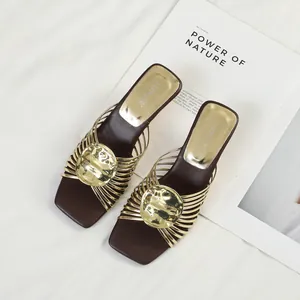 French style gold metallic sandals with radiating straps and irregular heel design