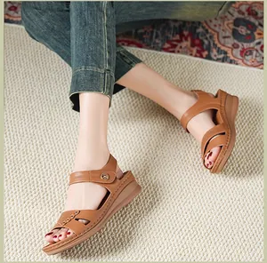 Détail de sandales compensées en cuir marron avec boucle en métal et semelle épaisse.