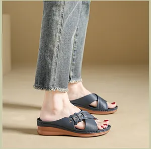 Detailed side view of women's dark blue wedge sandals with decorative laser-cut floral straps