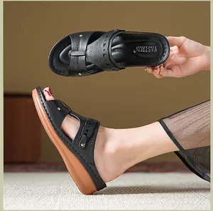Detailed view of black wedge sandals with perforated design and gold studs.