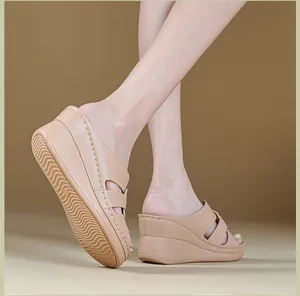 Detailed side view of elegant nude wedge sandals with prominent white stitching