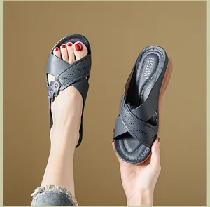Close-up of women's wedge sandals with perforated cross straps and soft brown sole