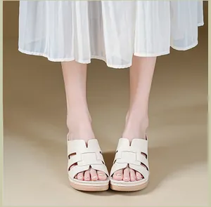 Close-up view of the stitched cross-cut upper of cream-colored platform wedge sandals for women