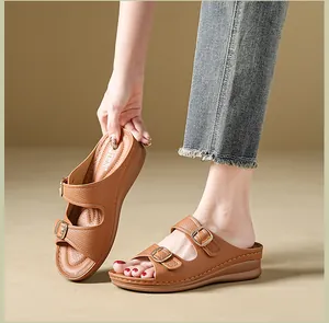 Detailed view of brown wedge sandals with double golden buckles and breathable insoles