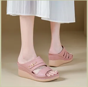 Detail of pink wedge sandals for women with elegant stitching and metal buckle