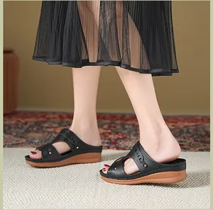 Detailed side view of women's comfortable black wedge sandals with hollow-out pattern design