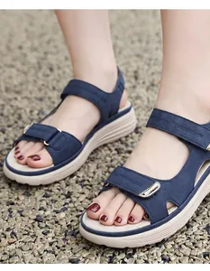 Close-up of navy blue sporty platform sandals with velcro straps on model's feet
