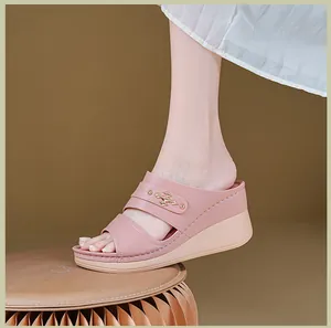 Detailed view of pink wedge sandals for women with gold-tone metal embellishment