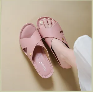 Détail des sandales compensées roses à brides croisées montrant la texture du cuir