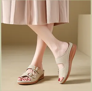 Detail view of stylish women's breathable wedge sandals with gold buckles on feet