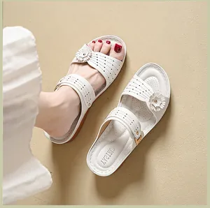 Detailed view of fashionable white wedge sandals with floral accents and laser-cut patterns