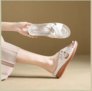 Detailed view of women's breathable off-white wedge sandals with elegant hollow patterns