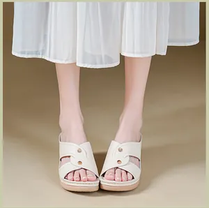 Elegant beige wedge sandals for women with comfortable cross-strap design and rivets.