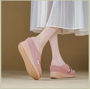 Détail de sandales compensées roses pour femmes avec coutures latérales et semelle antidérapante
