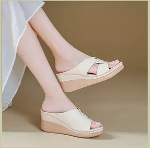 Side view of beige wedge sandals with cross-strap design and contrast stitching