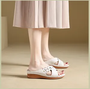 Close-up detail view of white wedge sandals with cross-strap design and soft cushioning