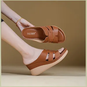 Detail view of brown women's wedge sandals featuring stitched upper and logo footbed