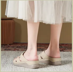 Vista posteriore di sandali con zeppa beige da donna con dettagli intagliati