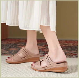 Detail shot of beige wedge sandals with floral hollow-out design worn with a skirt